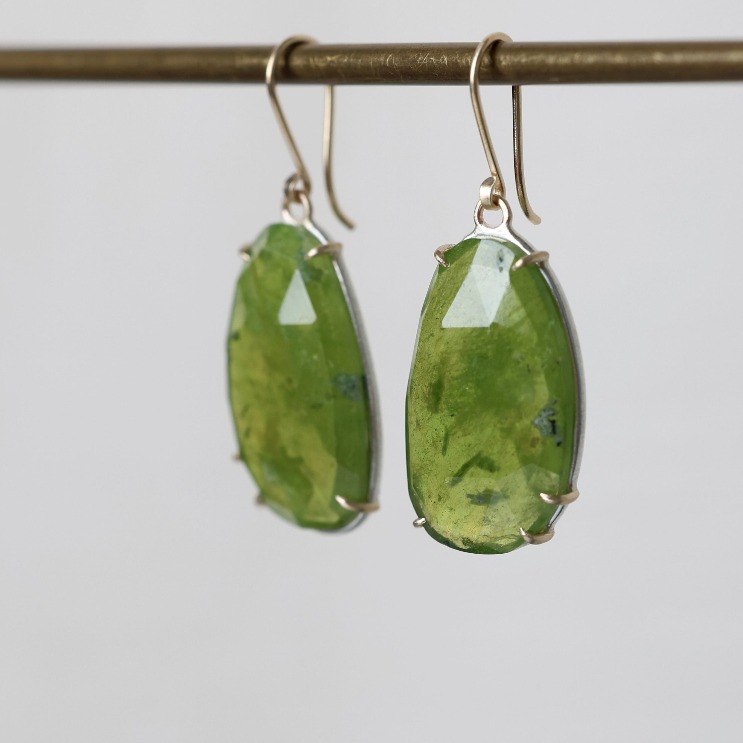 Green stone earrings on a gray background