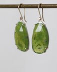 Green stone earrings on a gray background