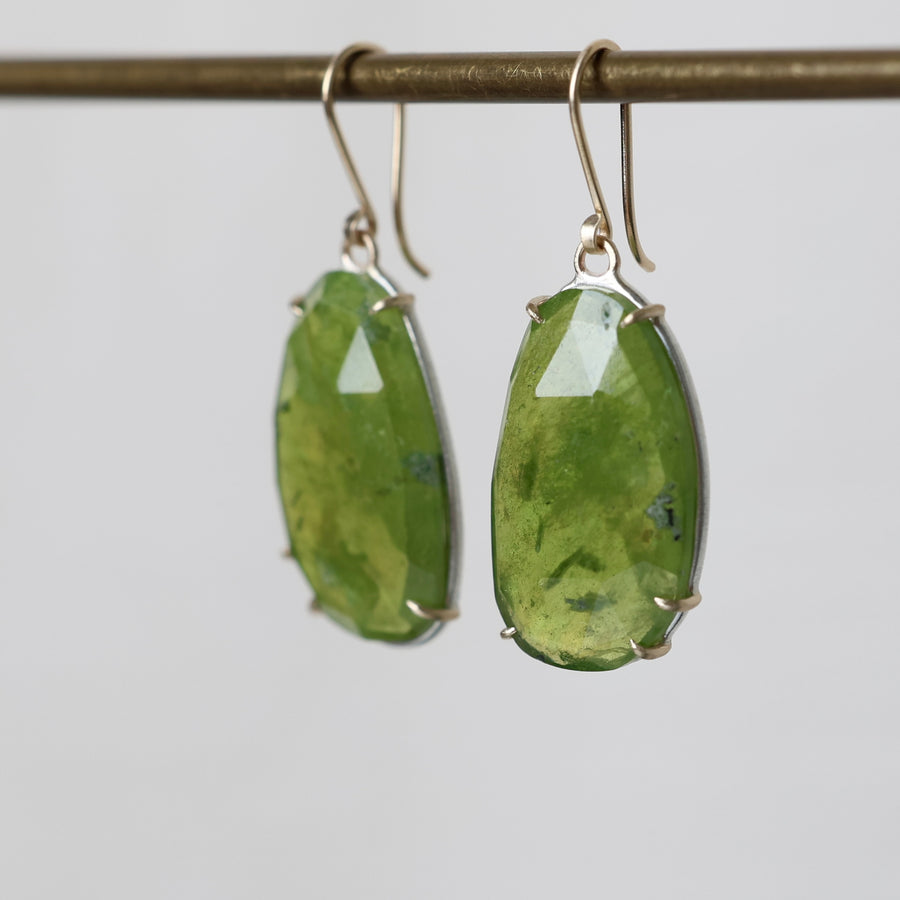 Green stone earrings on a gray background