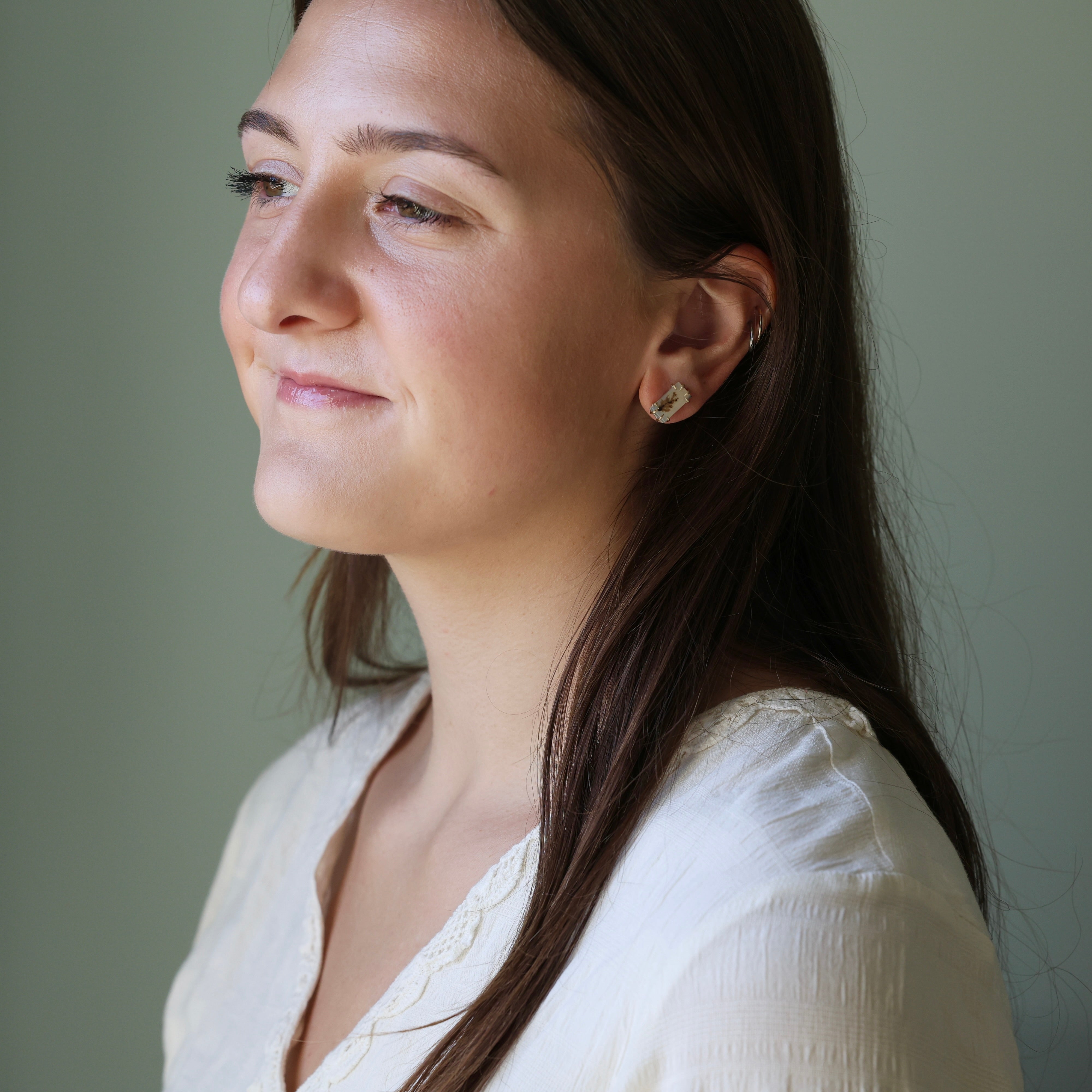 Woman wearing a white blouse against a plain background