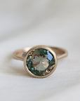 Ring with a green gemstone on a light fabric background