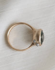 Gold ring with a gemstone on a light fabric background