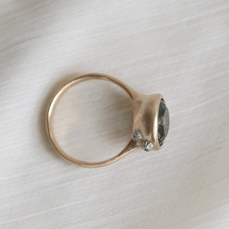 Gold ring with a gemstone on a light fabric background