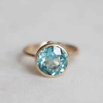Ring with a blue gemstone on a light gray background
