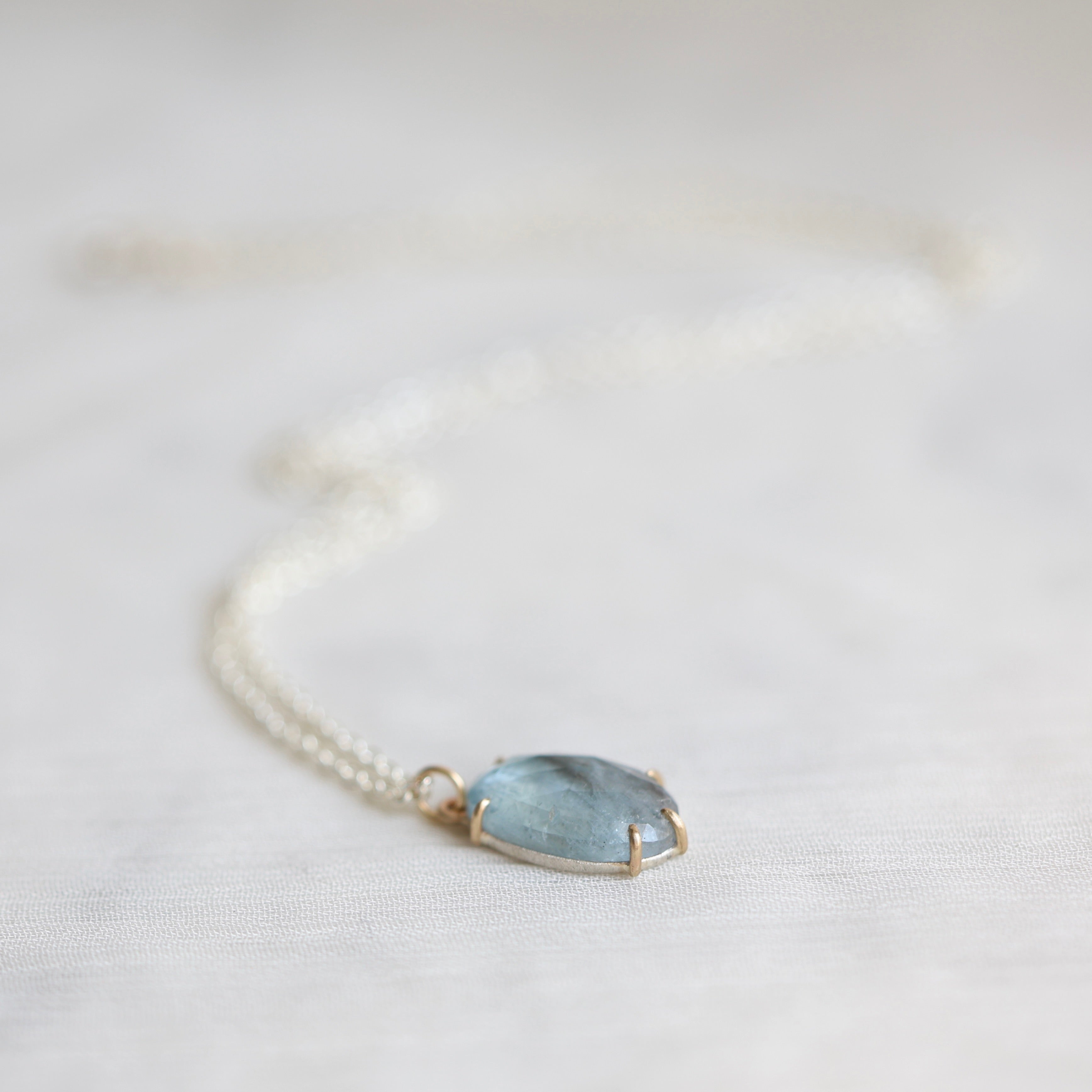 Necklace with a blue stone pendant on a light background
