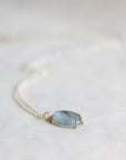 Necklace with a blue stone pendant on a light background