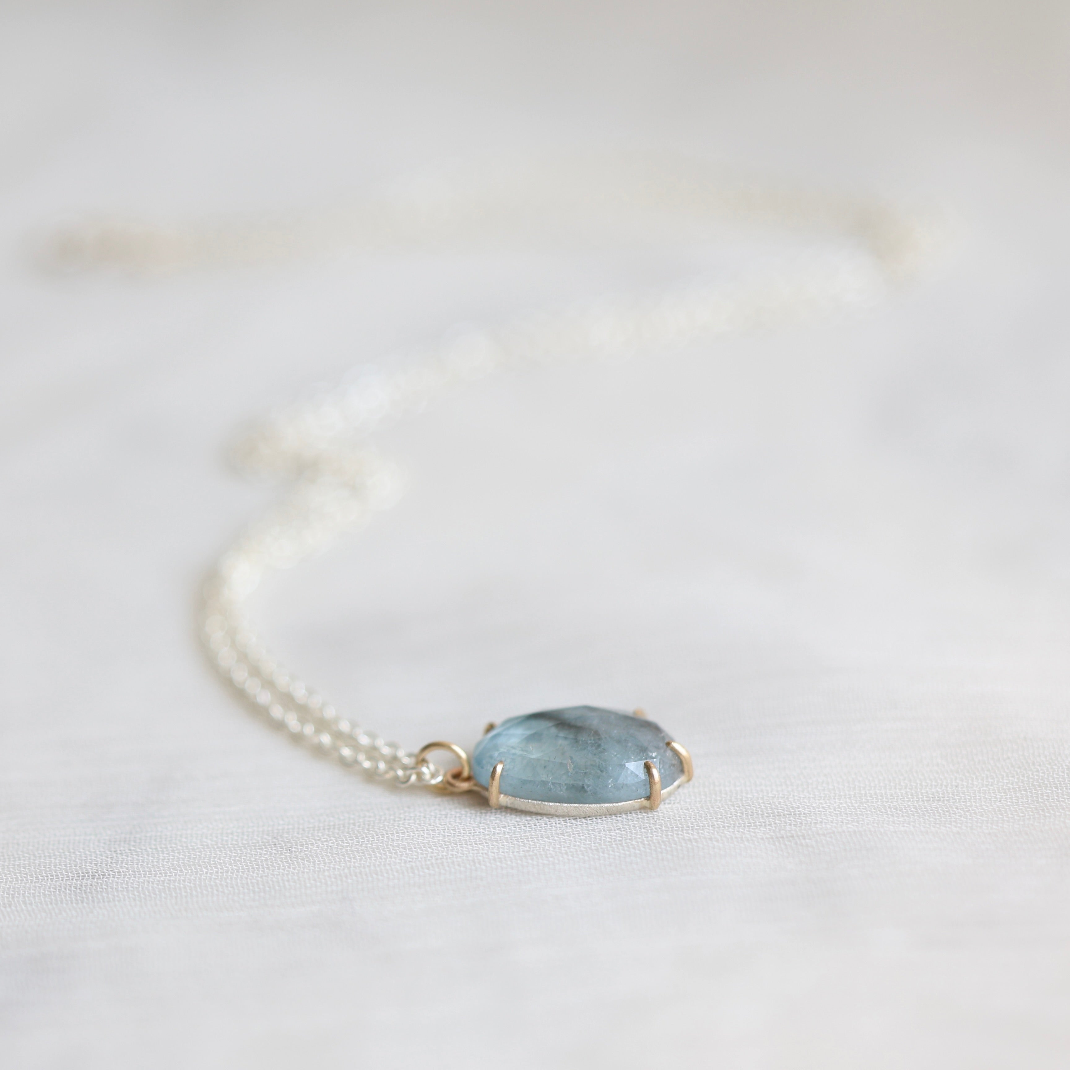 Necklace with a blue stone pendant on a white background