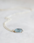 Necklace with a blue stone pendant on a white background