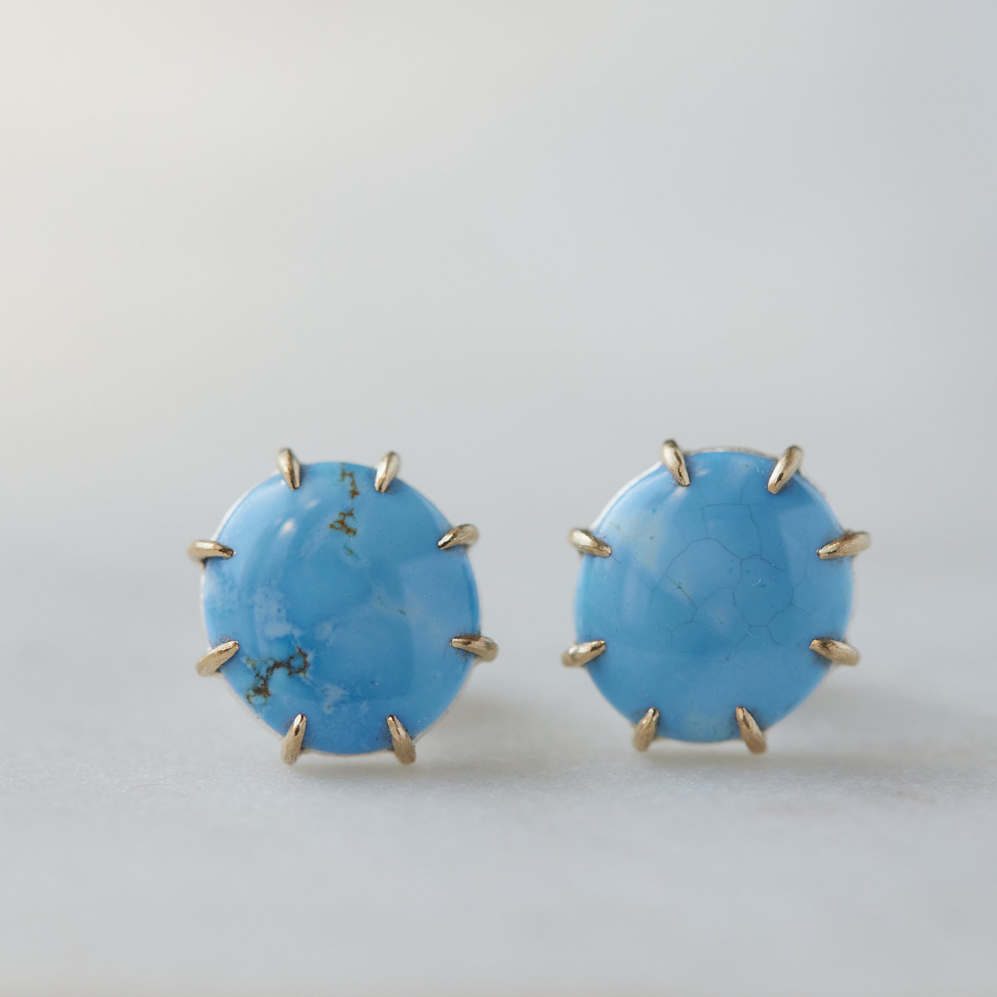 oval lavender turquoise cabochons are set in gold prongs in these stud earrings.