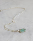 Necklace with a green opal pendant on a light background
