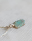 Necklace with a green opal pendant on a light background