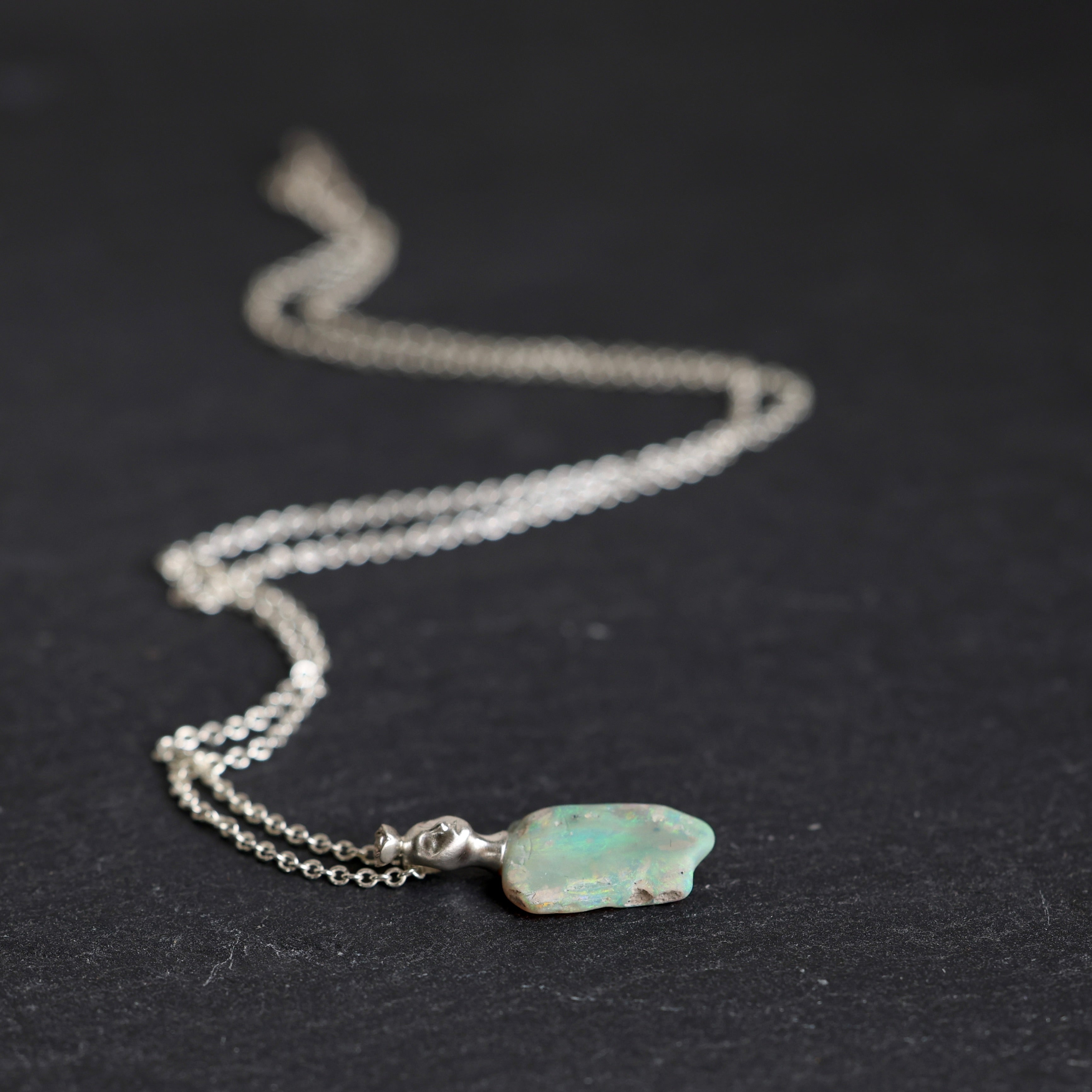 Necklace with an opal pendant on a black background