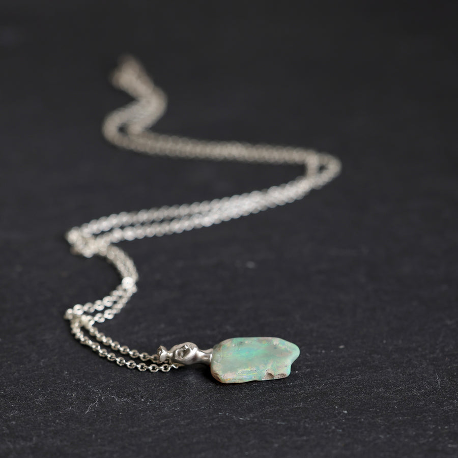 Necklace with an opal pendant on a black background