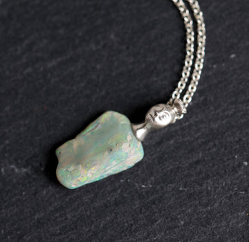 Necklace with an opal pendant on a black background