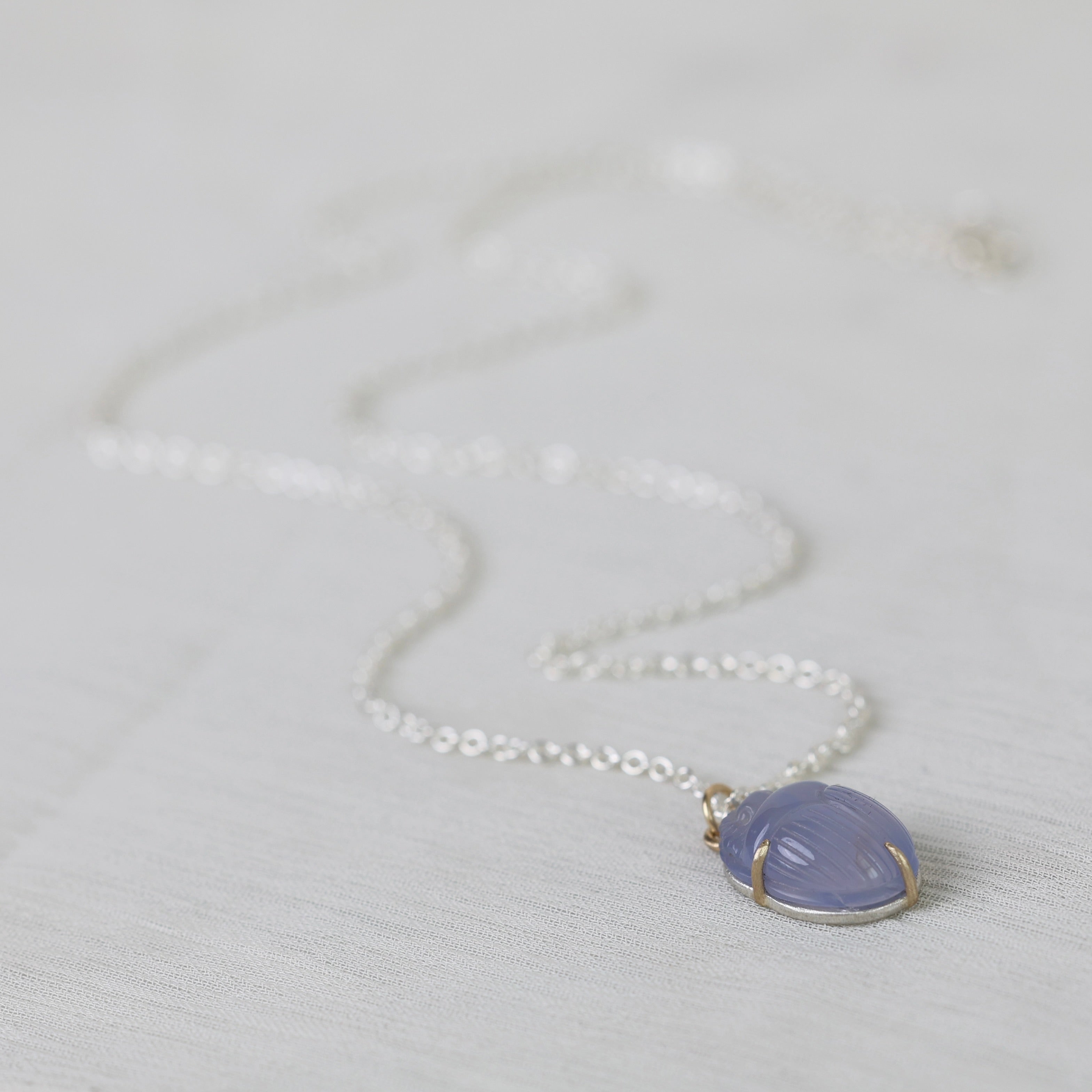 Necklace with a purple pendant on a light gray background
