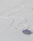 Necklace with a purple pendant on a light gray background