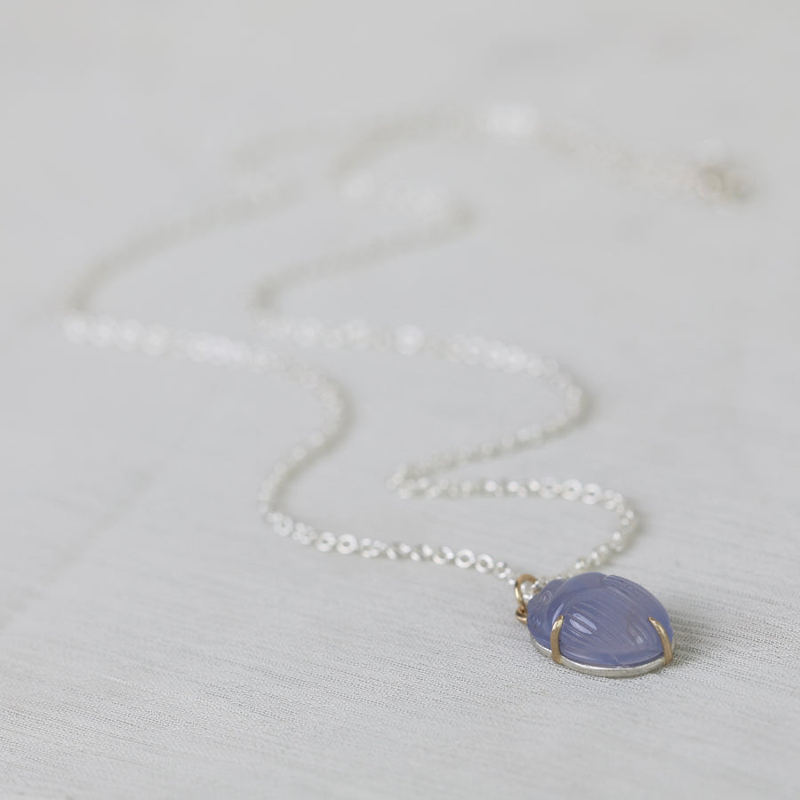 Necklace with a purple pendant on a light gray background