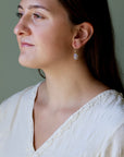Woman wearing a white top with a neutral background