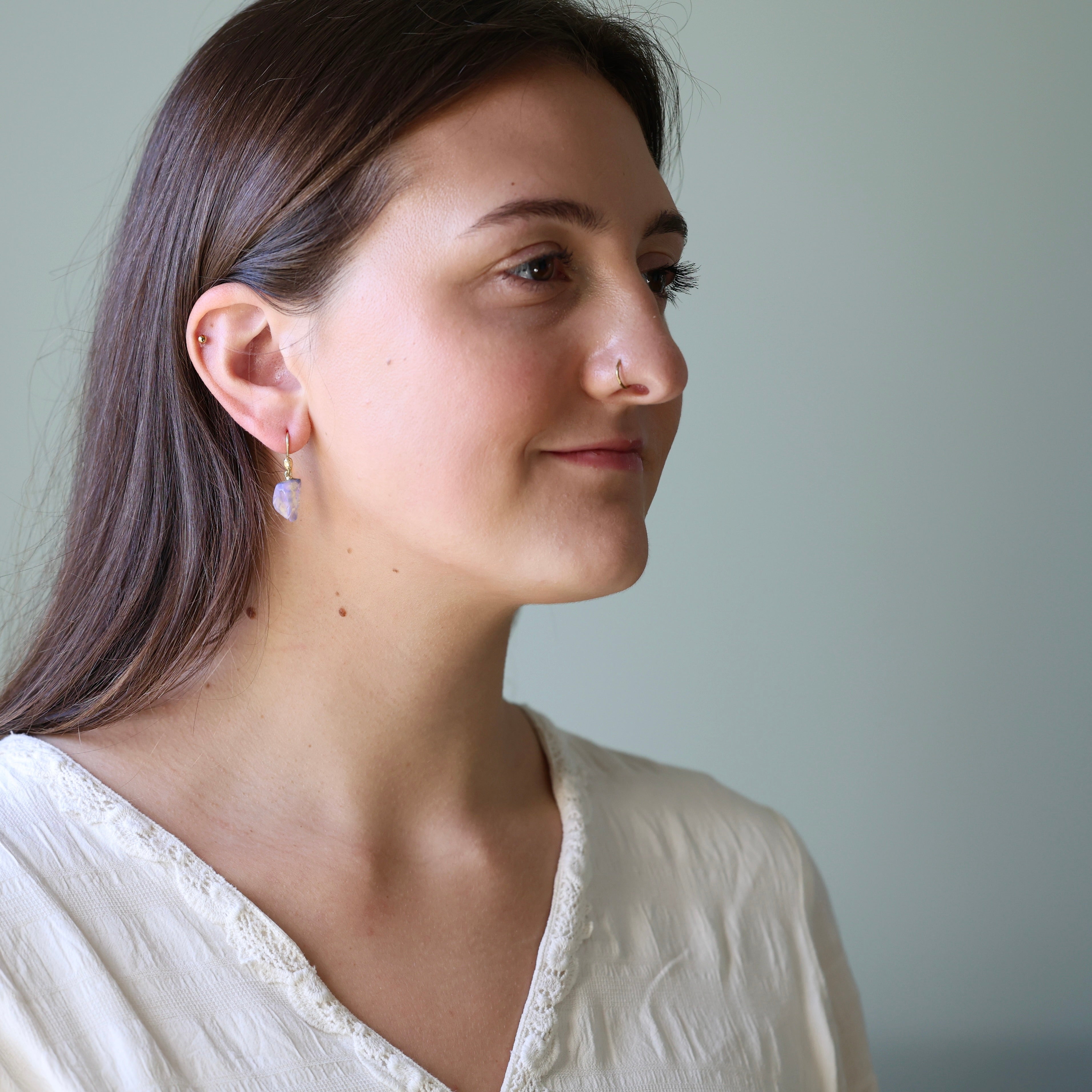 Woman wearing a white top against a plain background