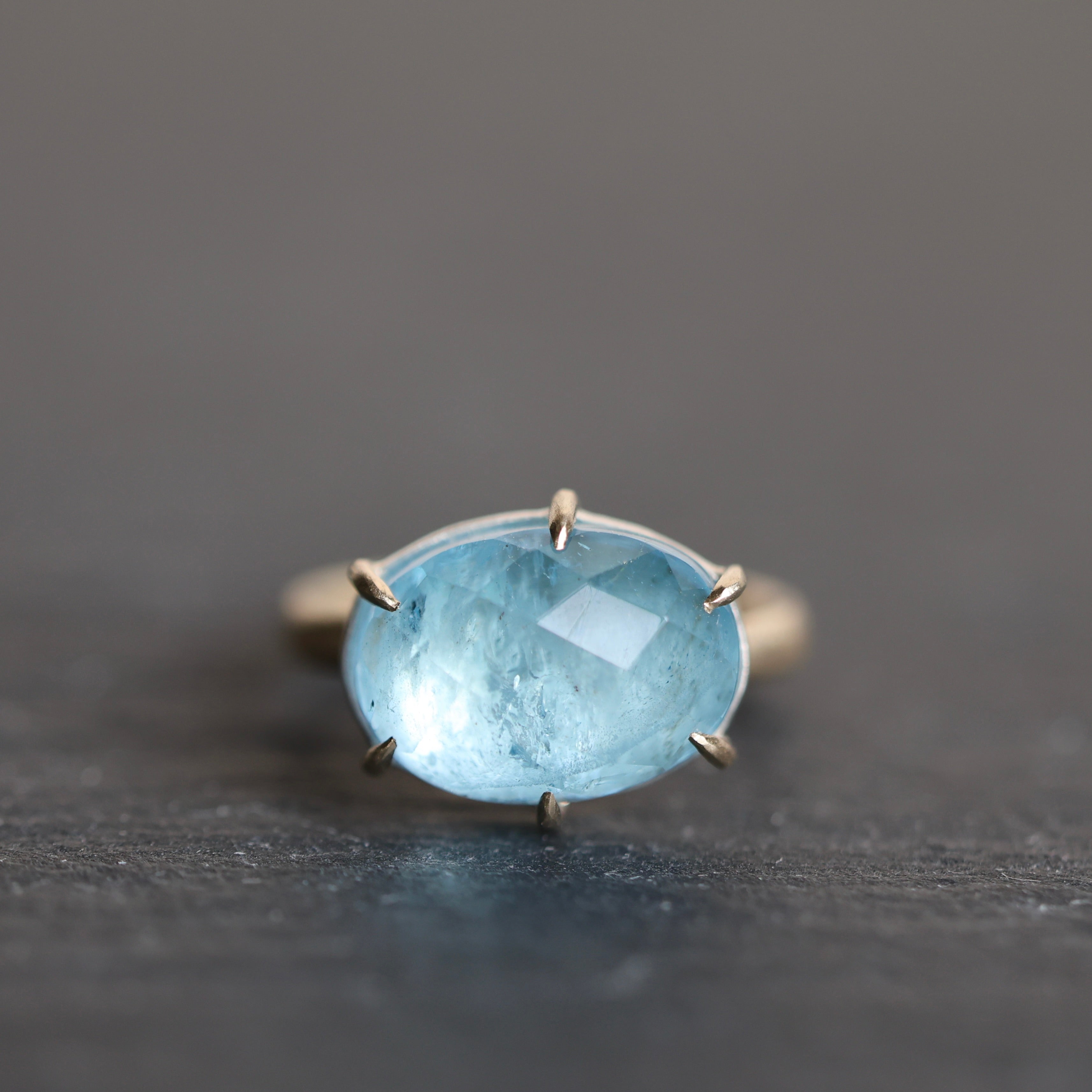 blue stone ring on a dark grey background
