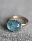 Gold ring with a blue gemstone on a gray surface