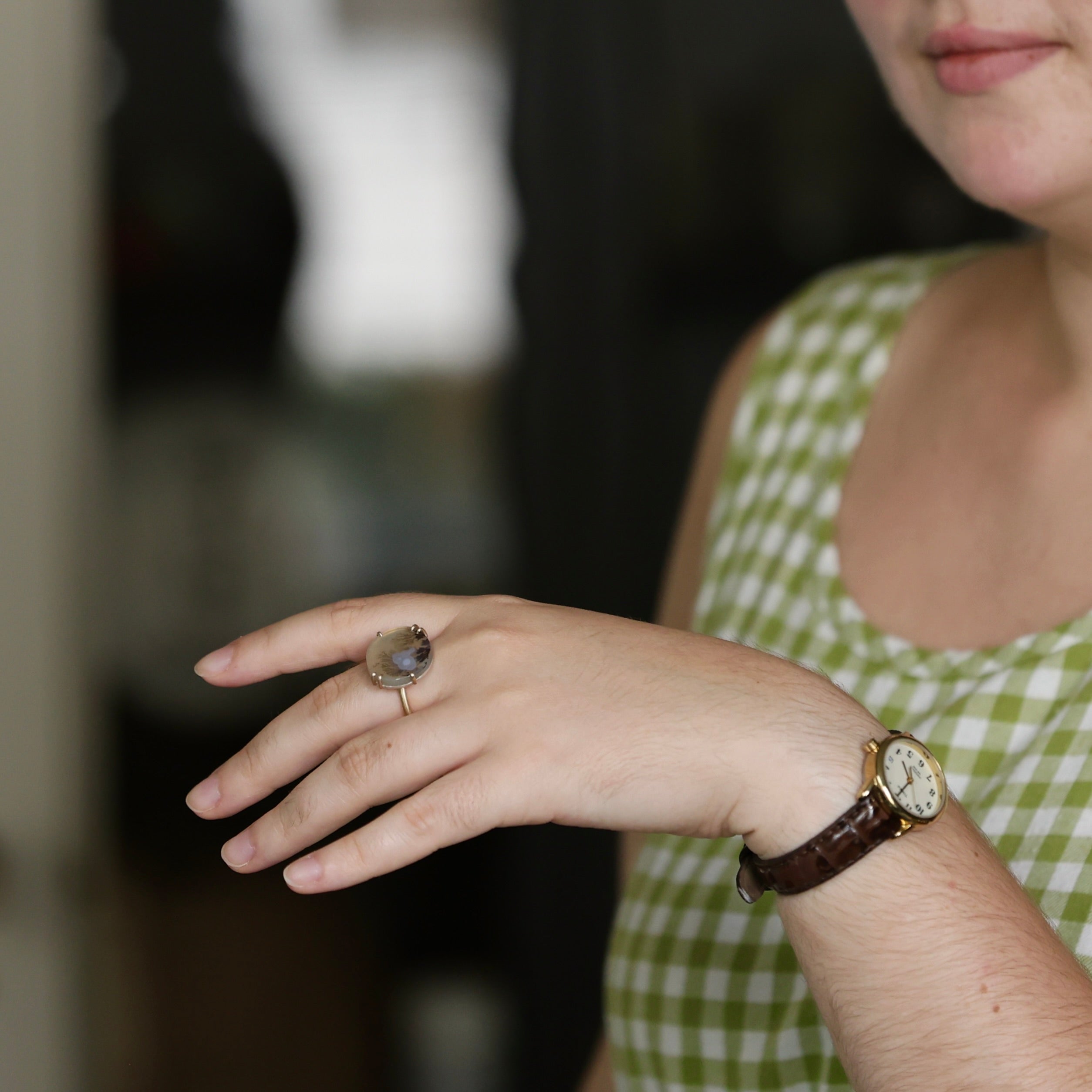 Person wearing a ring and watch with a blurred background
