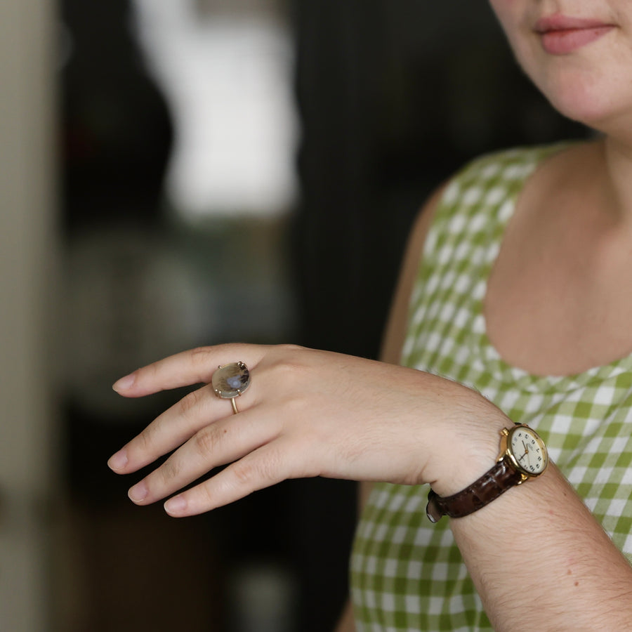 Person wearing a ring and watch with a blurred background