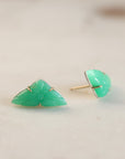 Pair of green triangular earrings on a light beige background