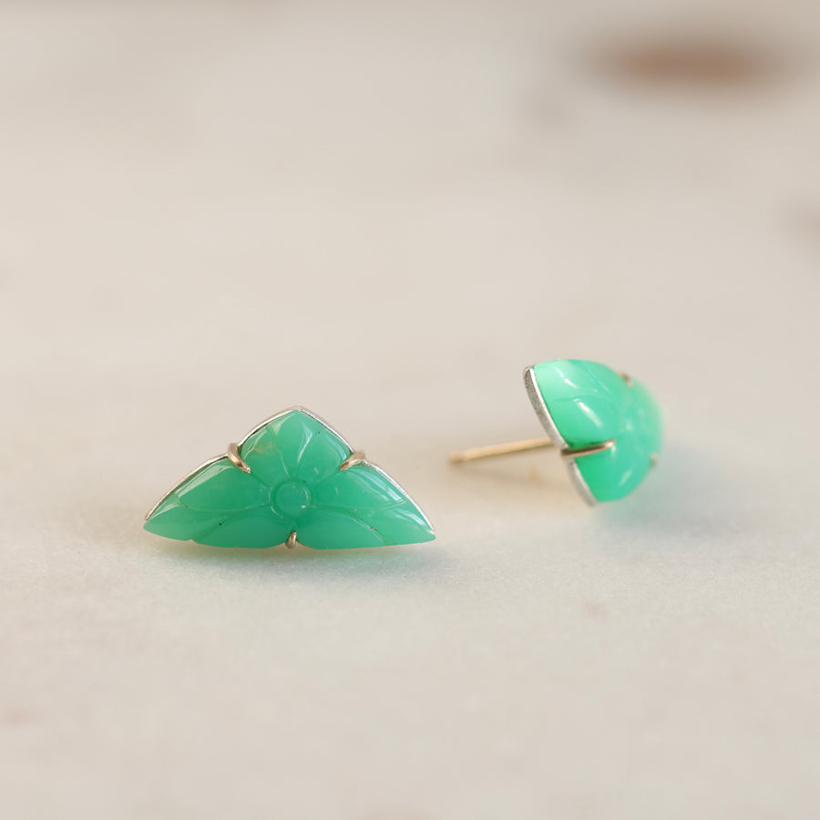 Pair of green triangular earrings on a light beige background