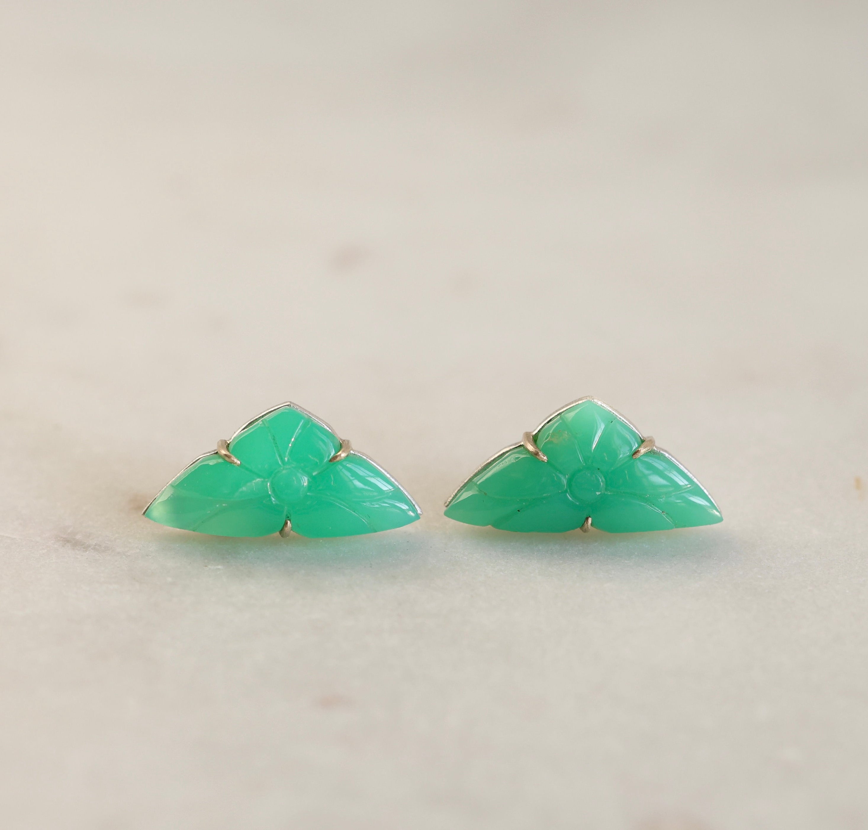 Pair of green triangle-shaped earrings on a light background