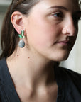 woman wearing dark grey shirt with green earrings