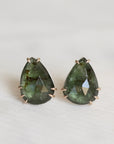 Pair of green teardrop-shaped earrings on a white background