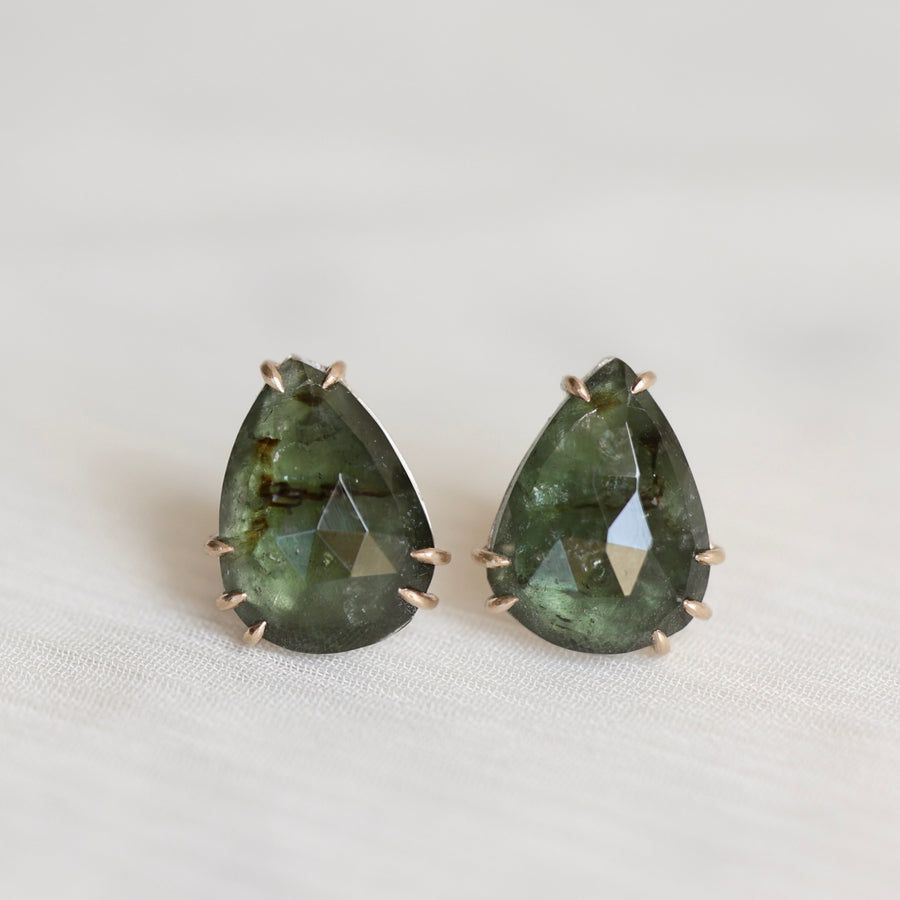 Pair of green teardrop-shaped earrings on a white background