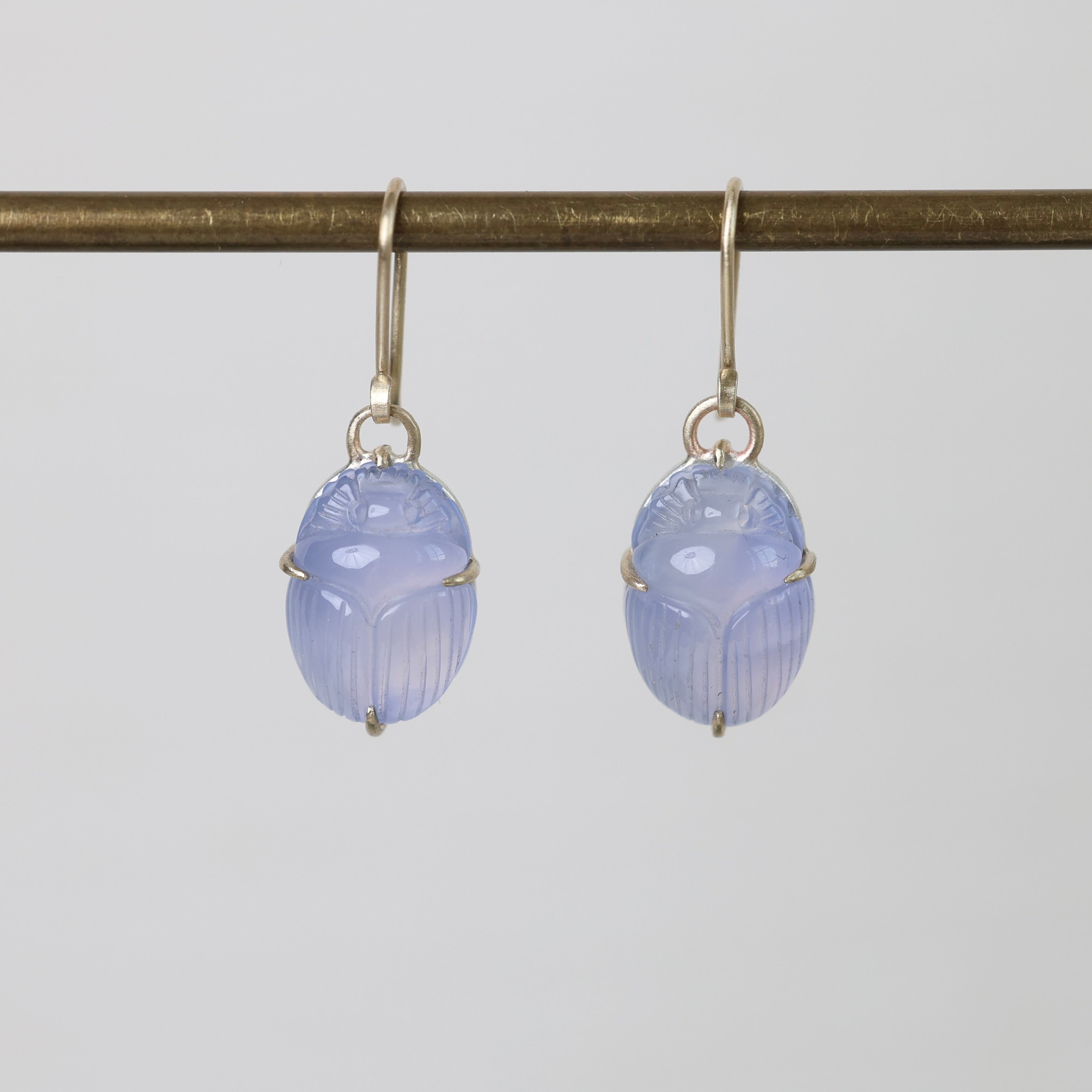 Pair of blue scarab earrings on a white background