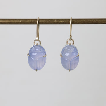 Pair of blue scarab earrings on a white background