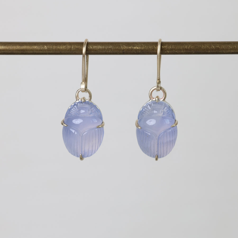 Pair of blue scarab earrings on a white background