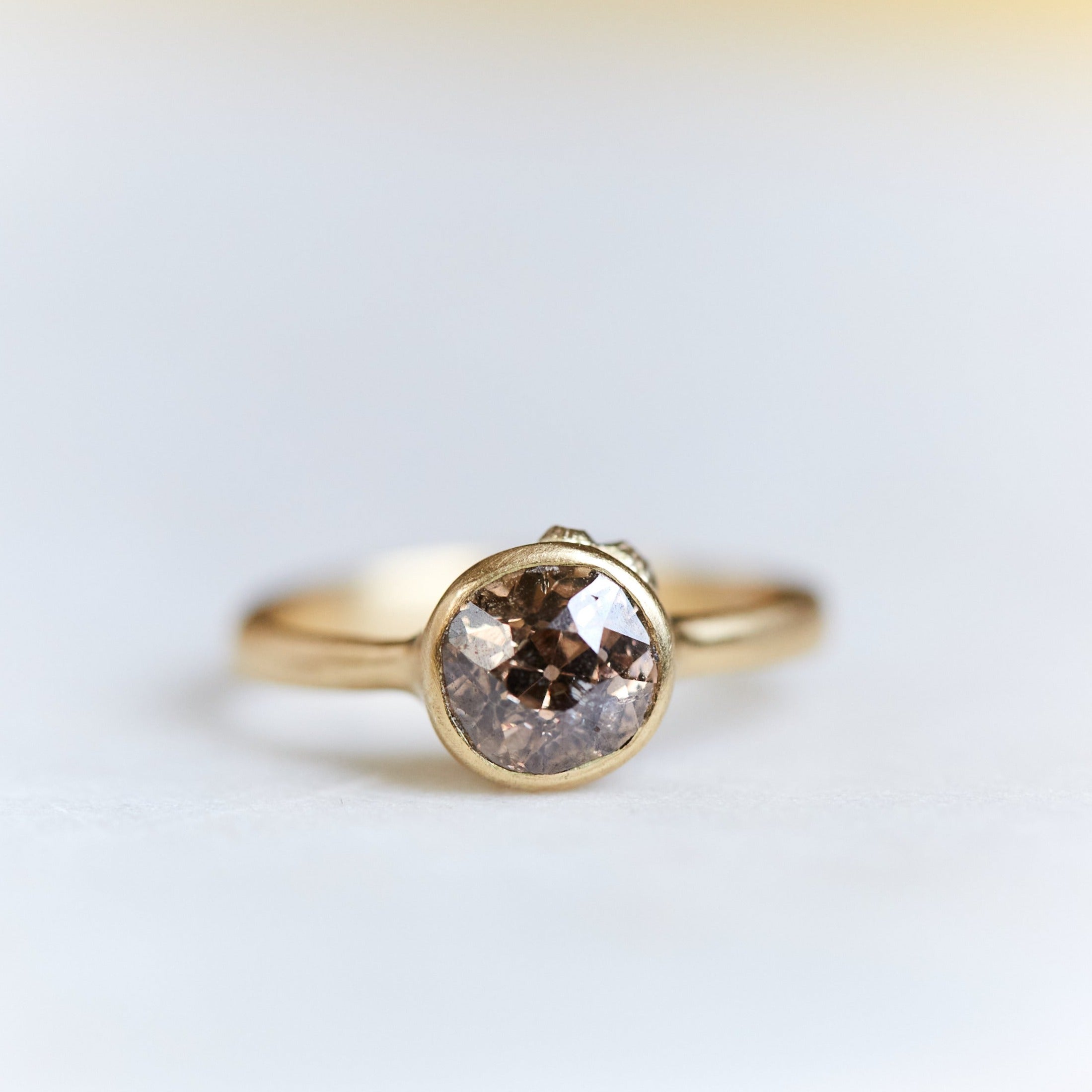 A 1.38ct diamond ring. The diamond has a chestnut hue and is set in 18k gold with an 18k gold band. The setting is encrusted with 14k gold barnacles. The ring is viewed from the front and is set on a white background.