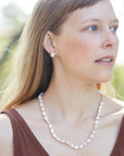 Baroque white freshwater pearl Ruthie B. necklace with coral-hued silk and silver clasp by Hannah Blount