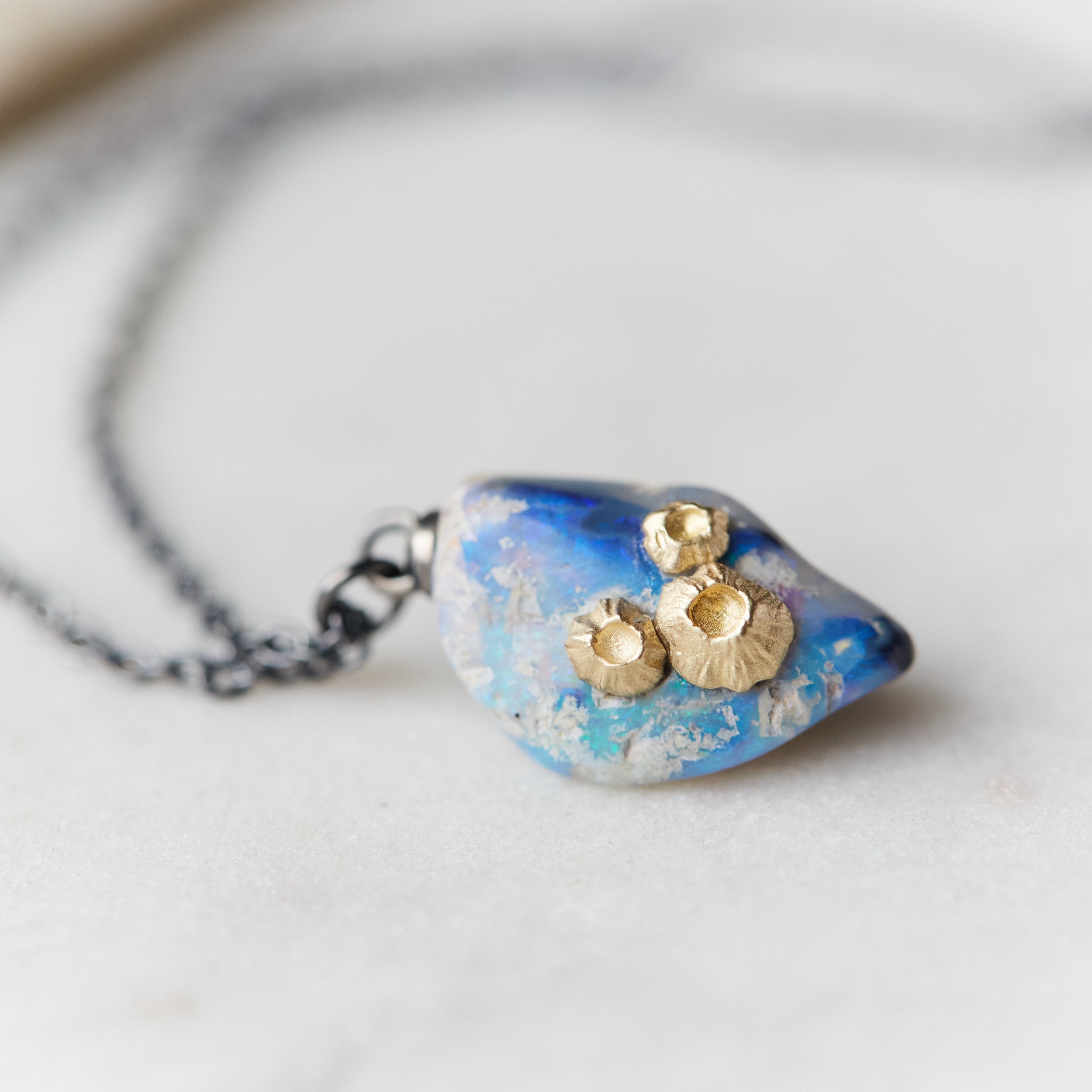 Raw opal with gold barnacles by Hannah Blount