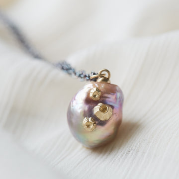 detail of pink freshwater baroque pearl necklace with gold barnacles and black oxidized silver chain by hannah blount jewelry