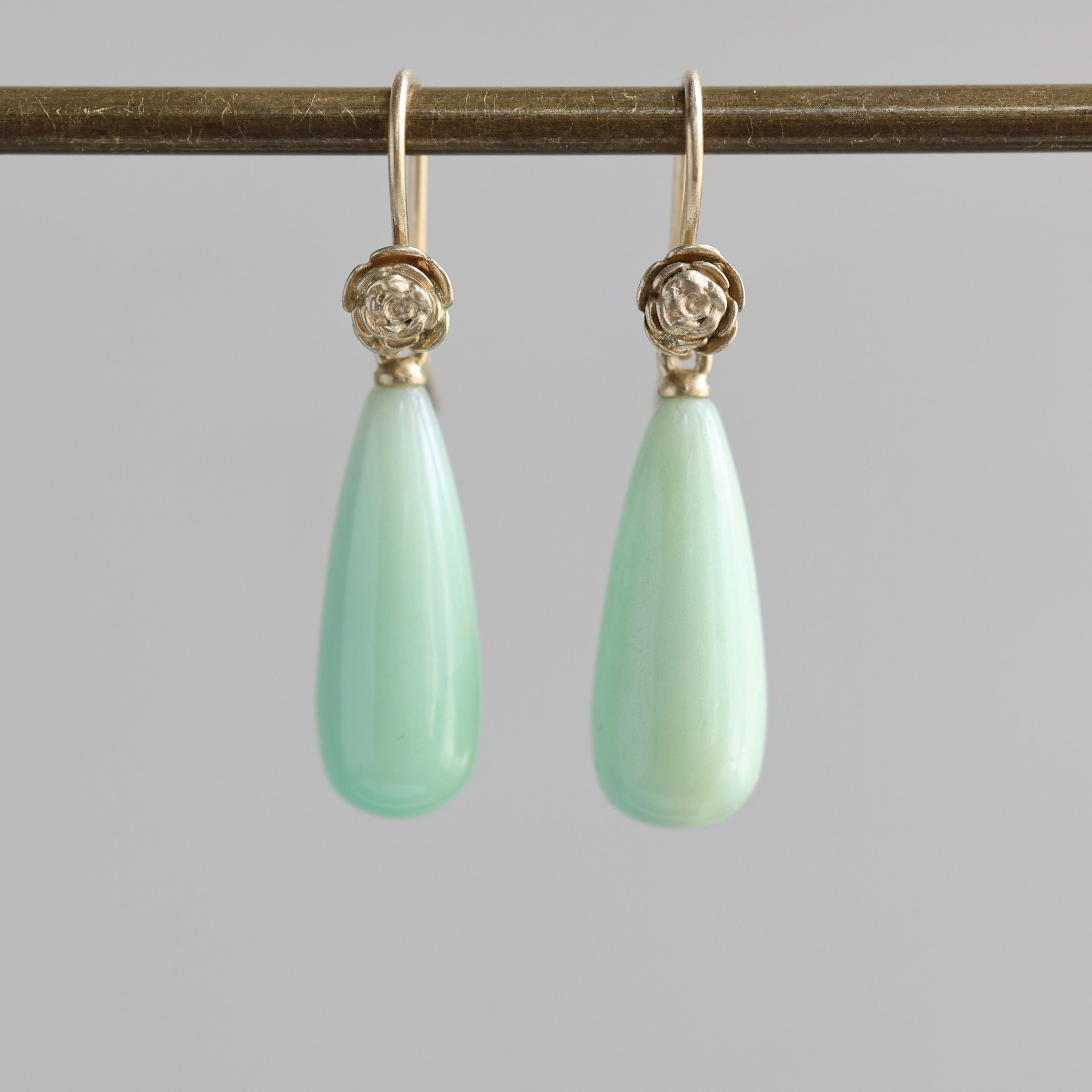 Teardrop shaped chrysoprase earrings with 14k yellow gold rose accents and ear wires. 