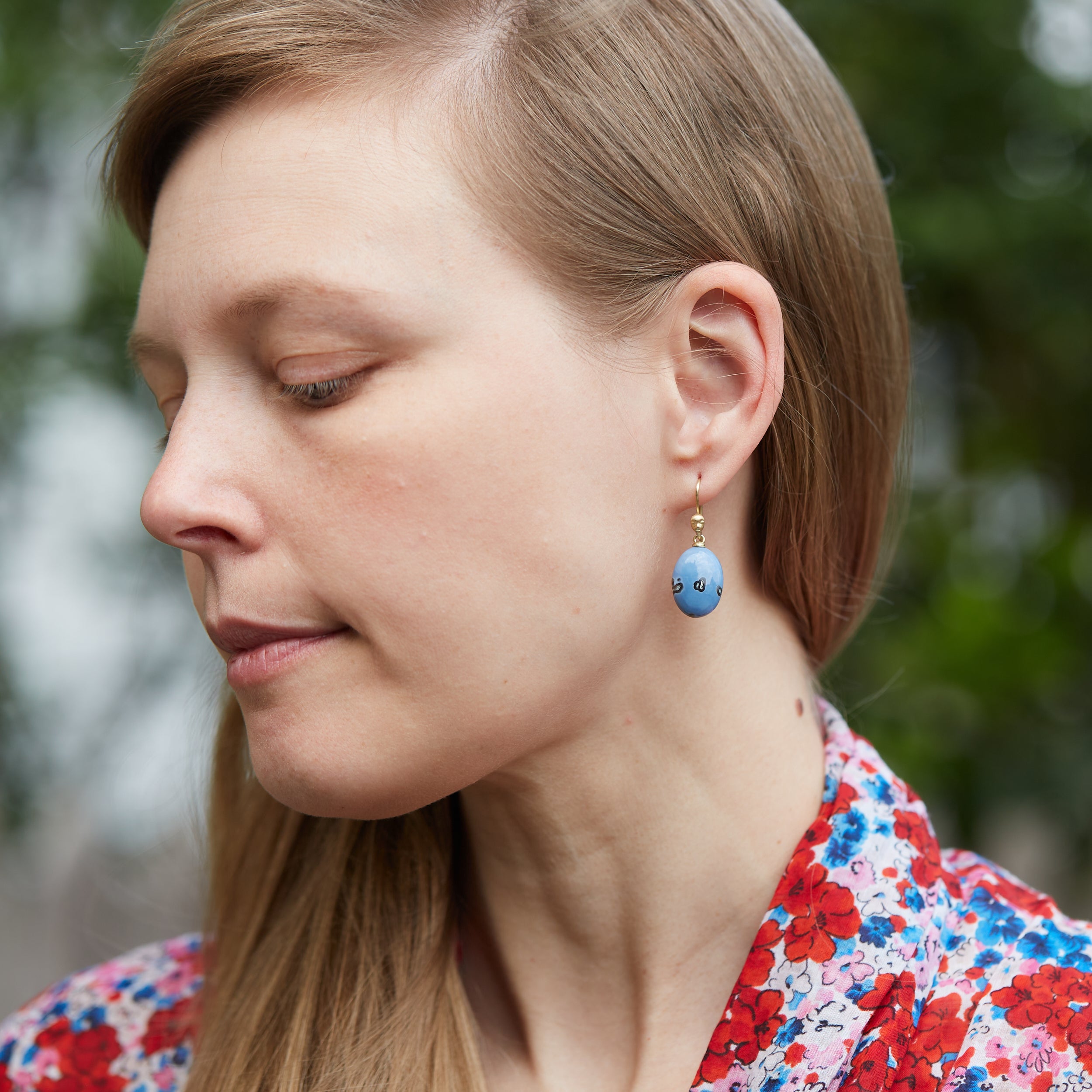 two pairs of periwinkle blue common opal with mottled black spots. on person.