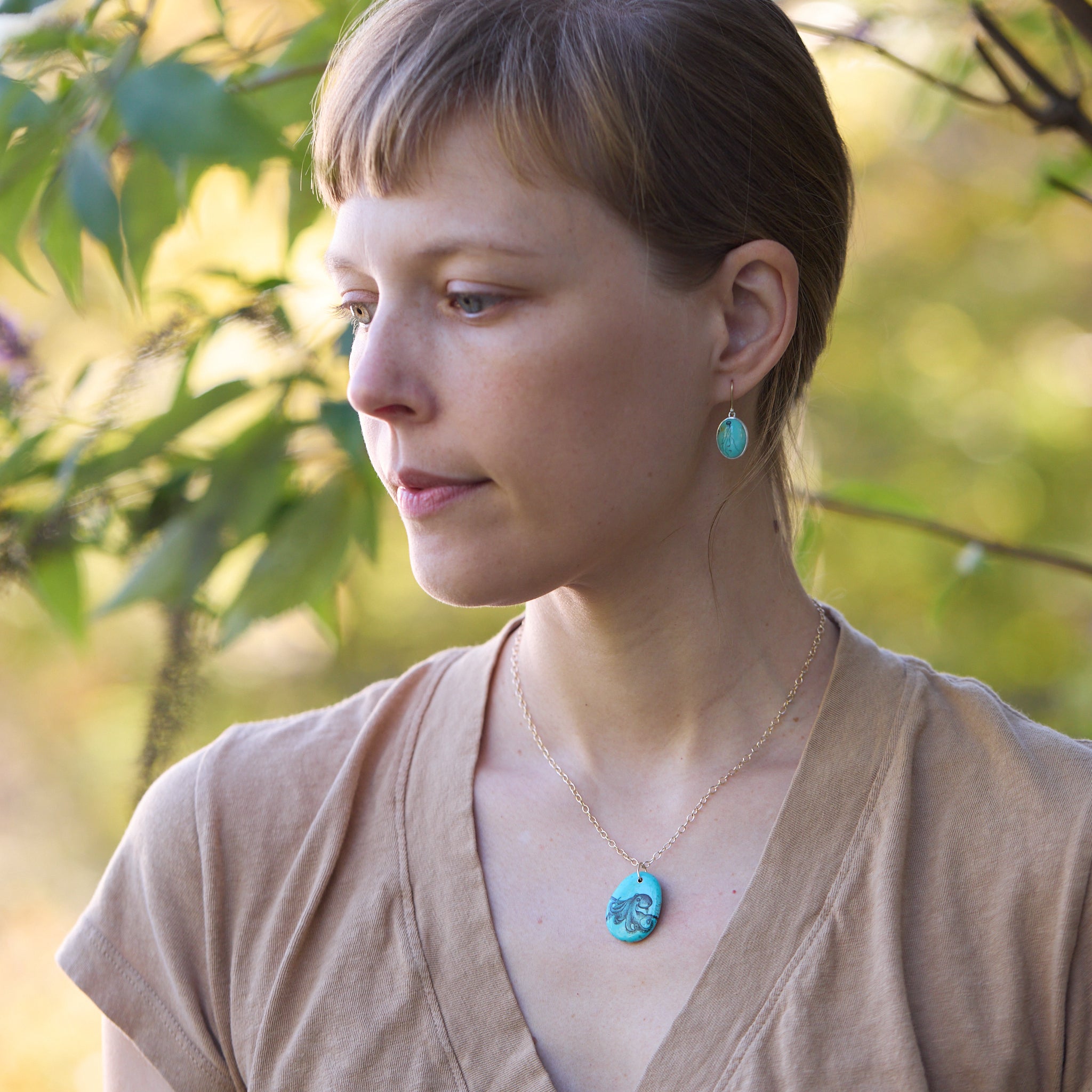 Woman wearing turquoise earrings and necklace outdoors