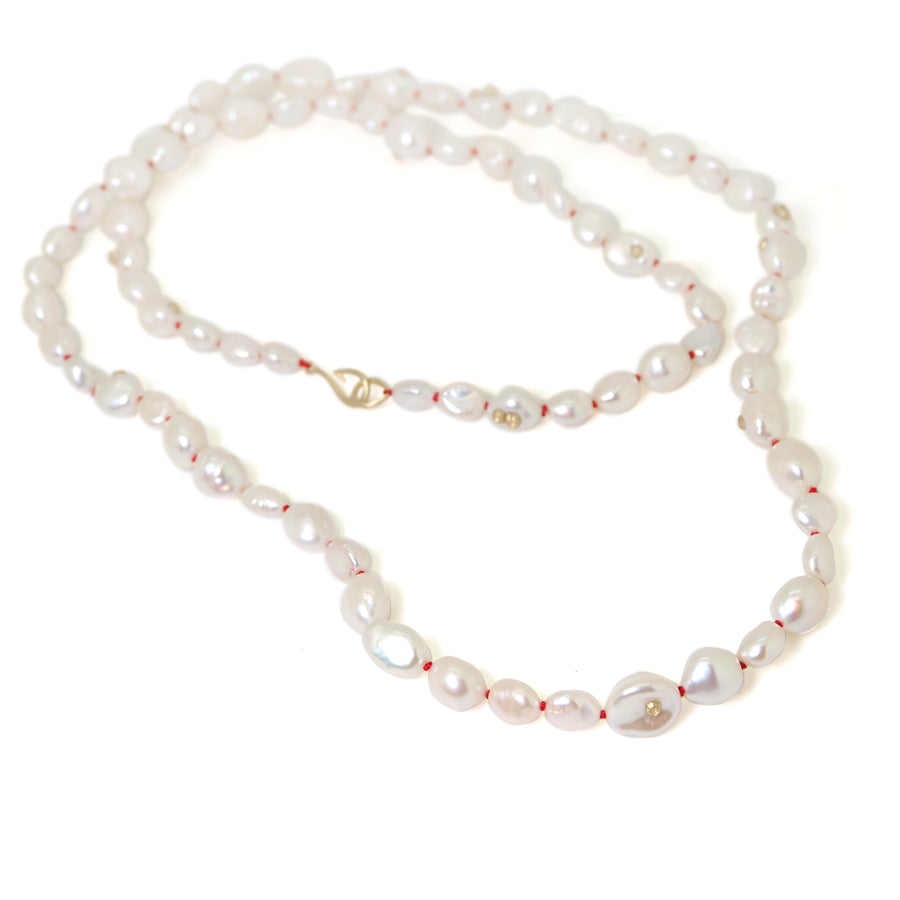 Baroque white freshwater pearl necklace with coral-hued silk and gold clasp by Hannah Blount