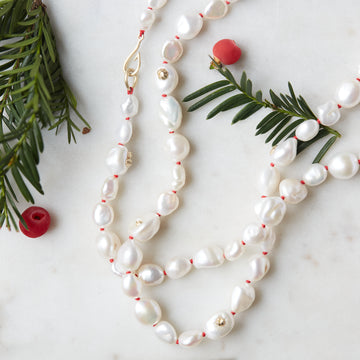 Baroque white freshwater pearl necklace with coral-hued silk and gold clasp by Hannah Blount- holiday version