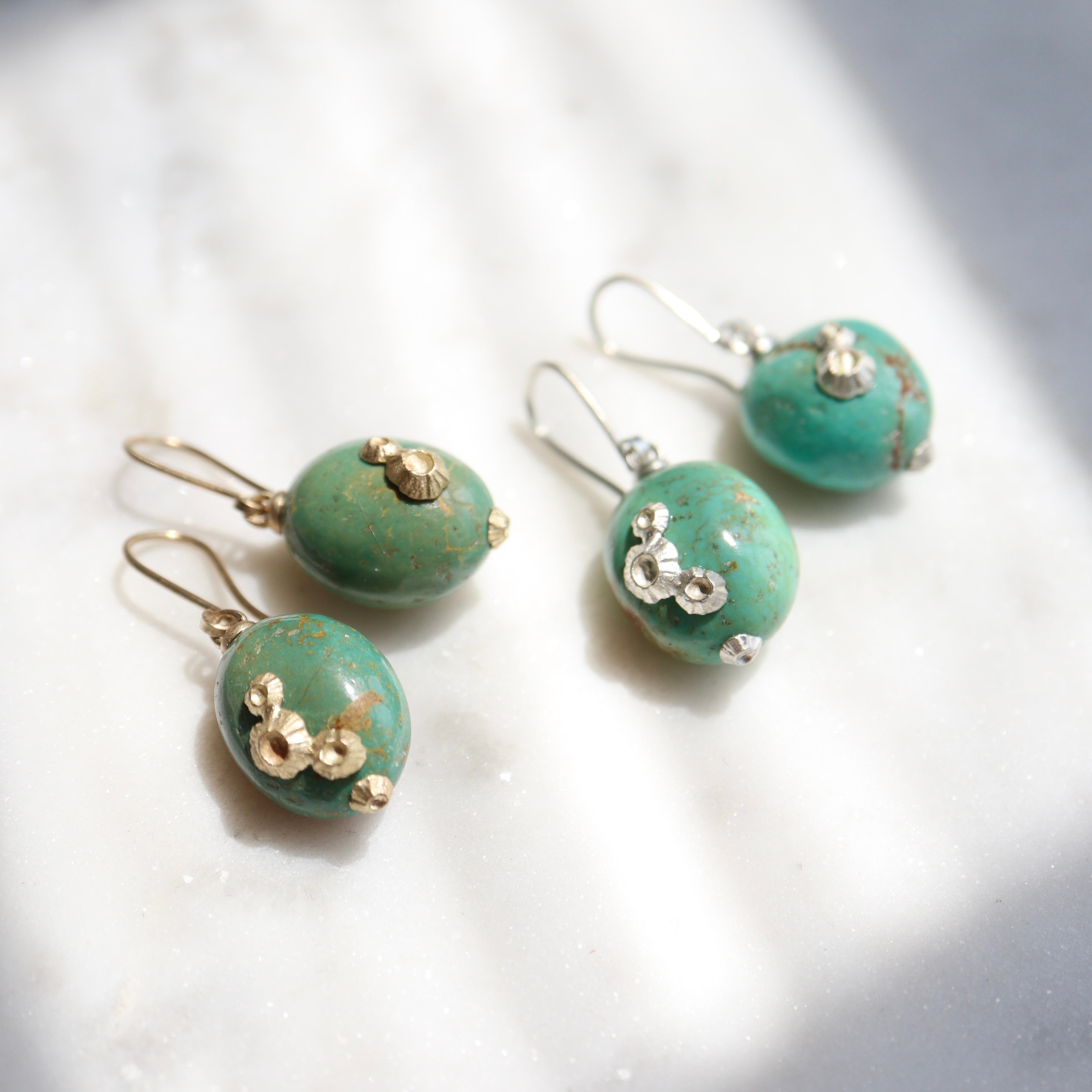 two pairs of blue green turquoise with barnacles, one with silver and one with gold.