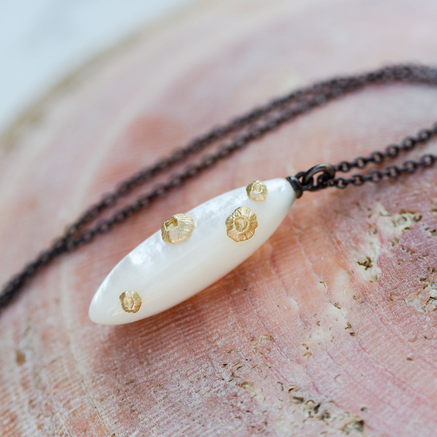 large mother of pearl necklace with oxidized black silver chain and gold barnacles by hannah blount
