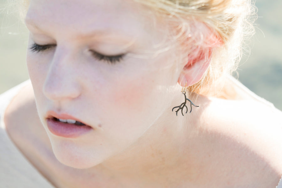 oxidized silver branch earrings on person by hannah blount