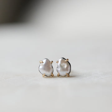 tiny white abstract pearl studs with gold prongs by hannah blount