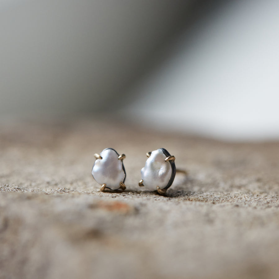 tiny white abstract pearl studs with gold prongs by hannah blount